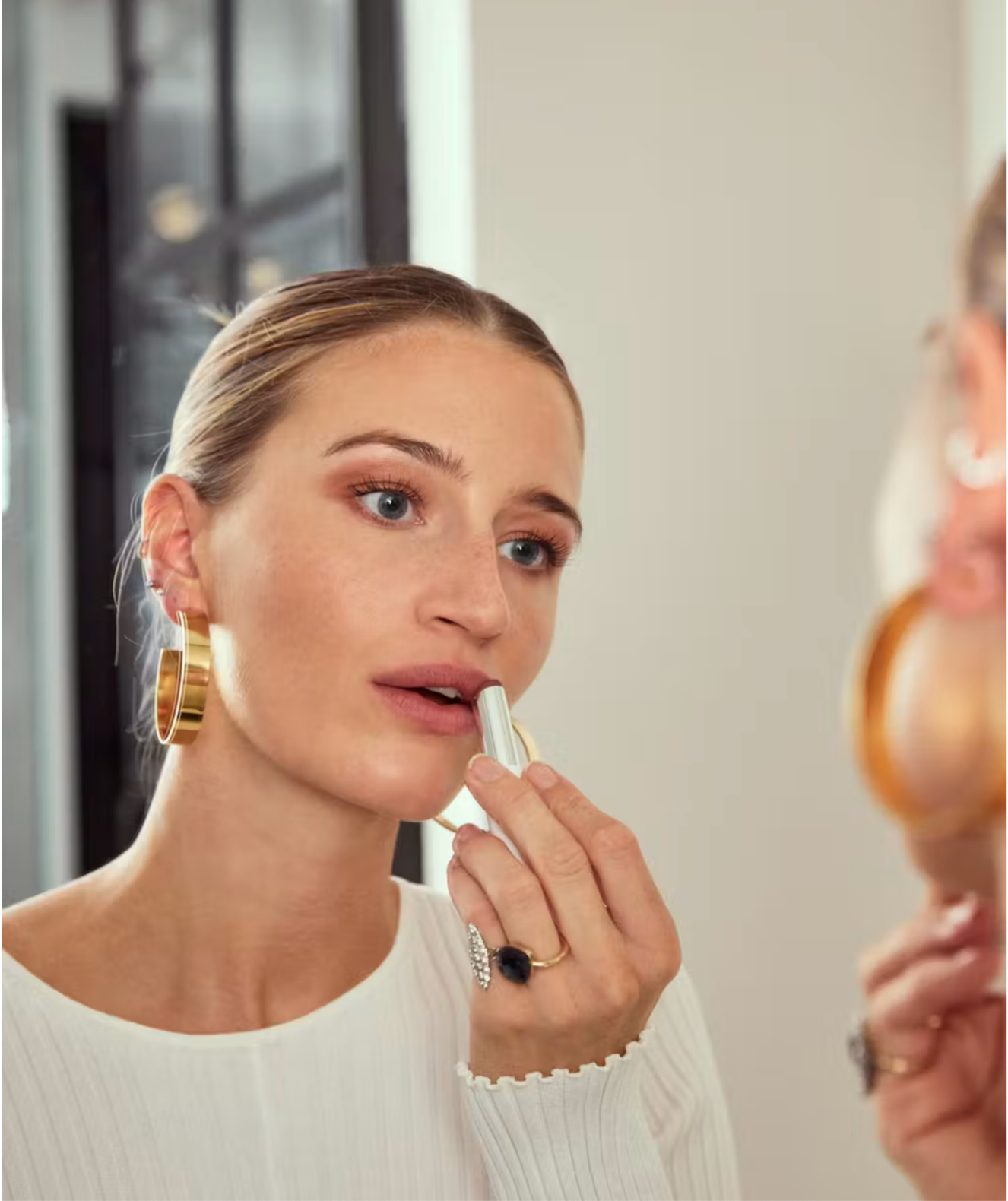 Rikke Sandvold applying lip balm while getting ready for her beauty and skincare routine.