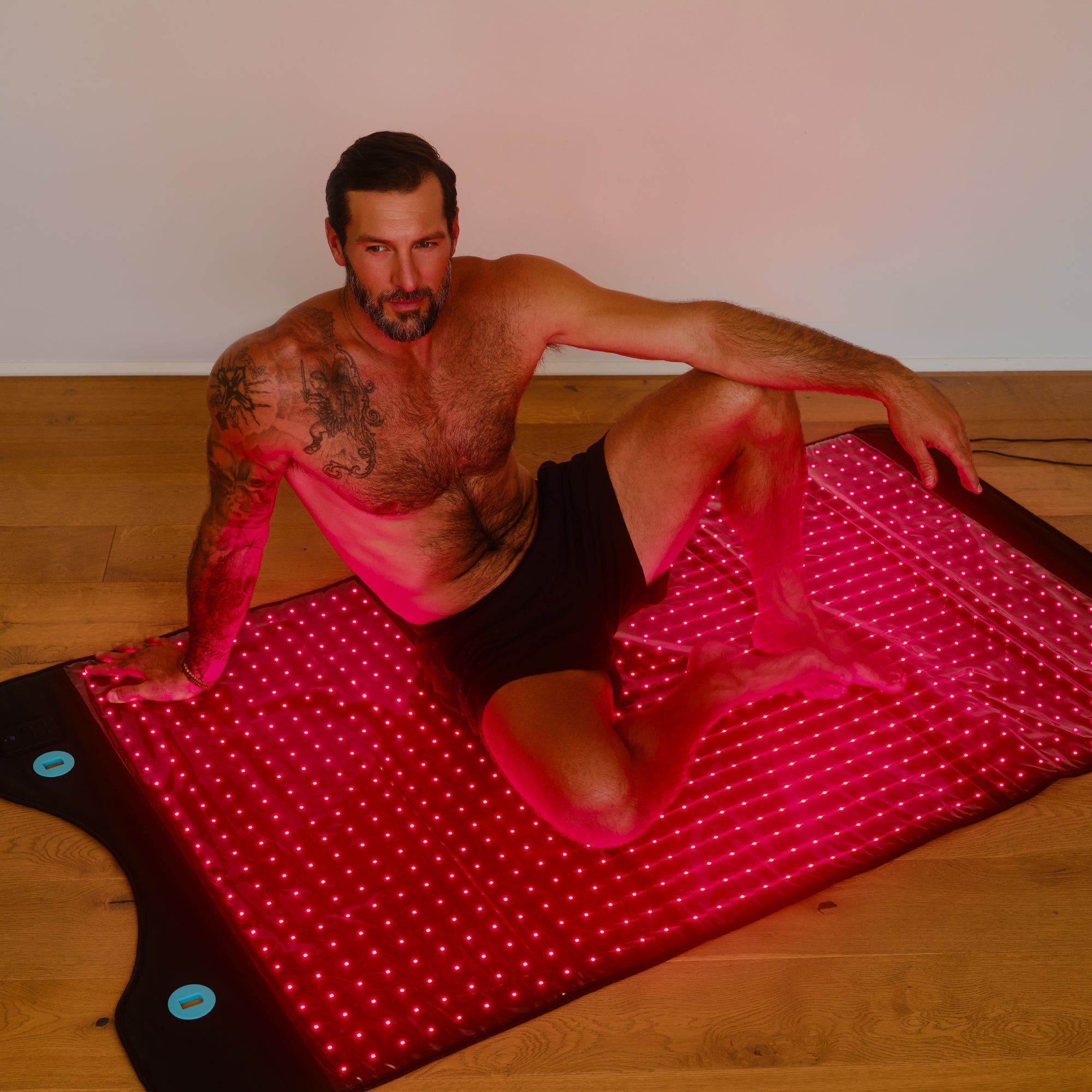 Man reclining on Full Body Red Light Mat