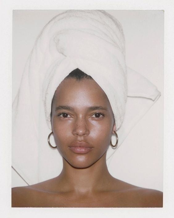 Woman with a towel wrapped around her hair, bare skin and a soft glow